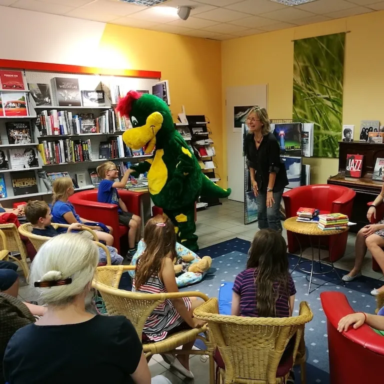 Drache Dinoli bei einer Kinderlesung in einer Buchhandlung
