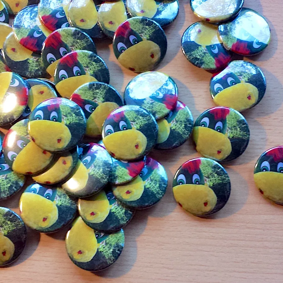Viele fertige Ansteck-Buttons mit Drache-Dinoli-Motiv